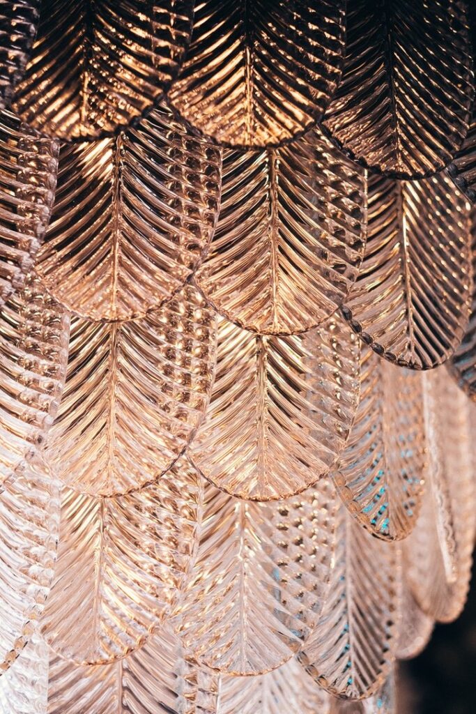 Close-up detail of a sculptural chandelier with textured glass leaves.