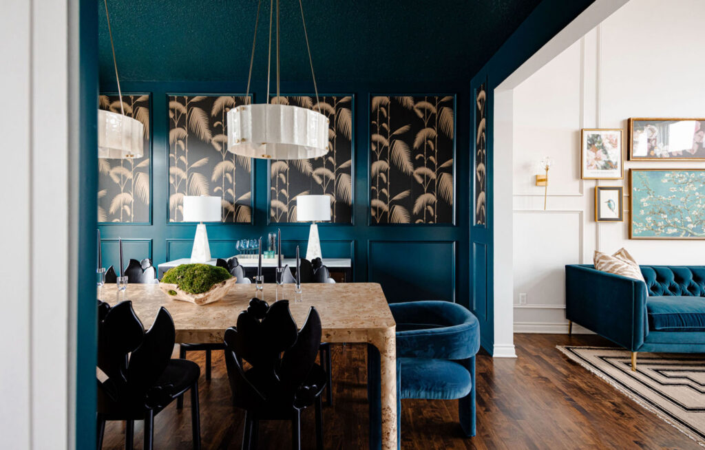 Moody dining room featuring teal paneling, palm-pattern wall panels, and a stone dining table.