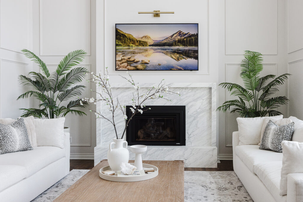 Elegant living room renovation with marble fireplace, wood coffee table, and layered neutral textures.