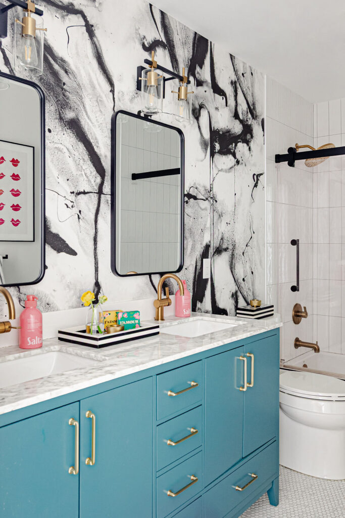 Vibrant Minneapolis-St. Paul bathroom with teal double vanity, marble countertop, and abstract black-and-white wall art. This bold remodel showcases the design team's flair for artistic layering, boutique detailing, and high-end finishes in everyday spaces.